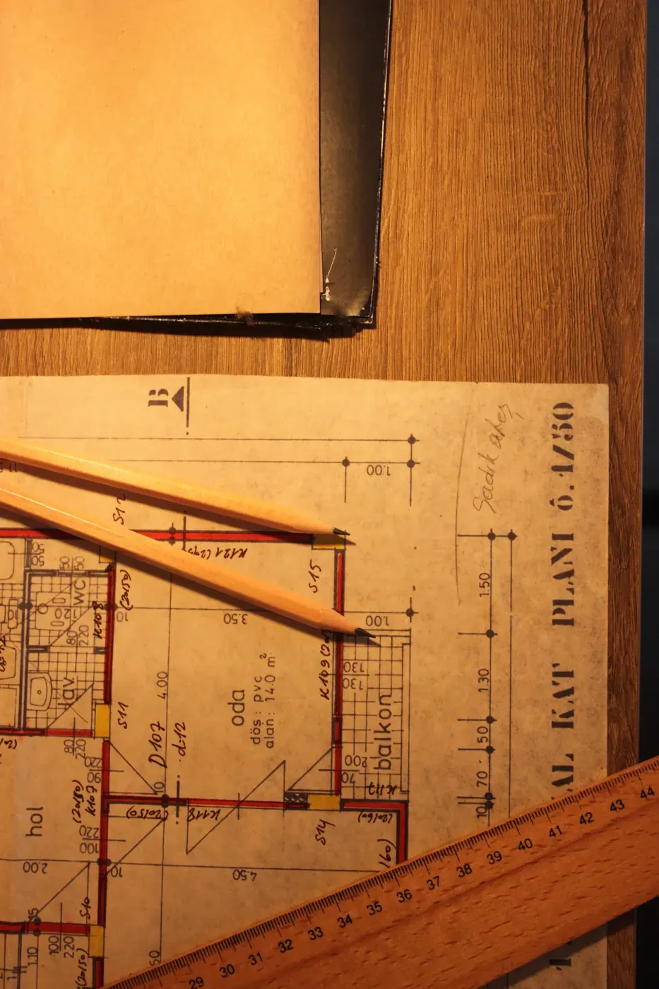 Floor plan sheet, ruler and pencils on a drawing desk